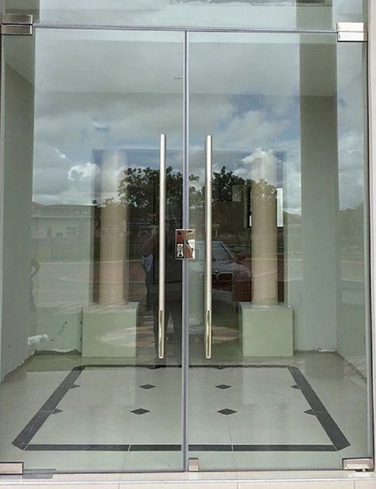 Heavy, closed wooden double doors that need to be pulled open.